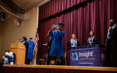 JaQuan celebrates on stage after receiving his high school diploma at the Insight Academy of Arizona graduation ceremony.